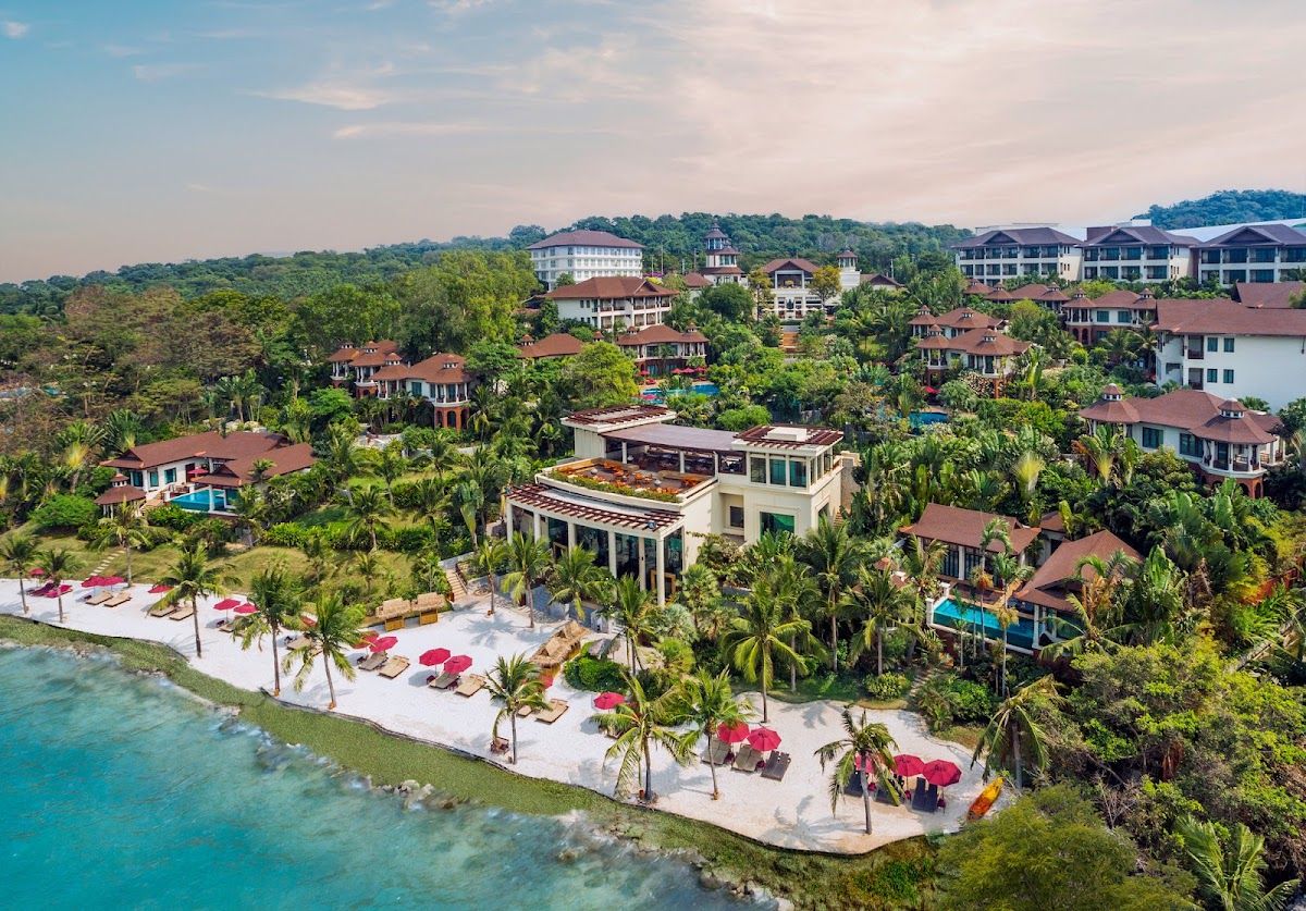 Aerial view of the InterContinental Pattaya Resort with its private white-sand beach, red sun loungers and tropical villa complex nestled among palms on Pratumnak Hill
