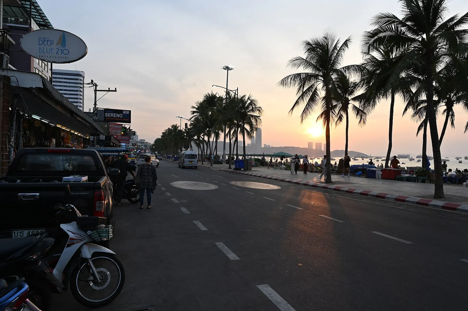 Beach Road in Pattaya at sunset, scooters parked under palms