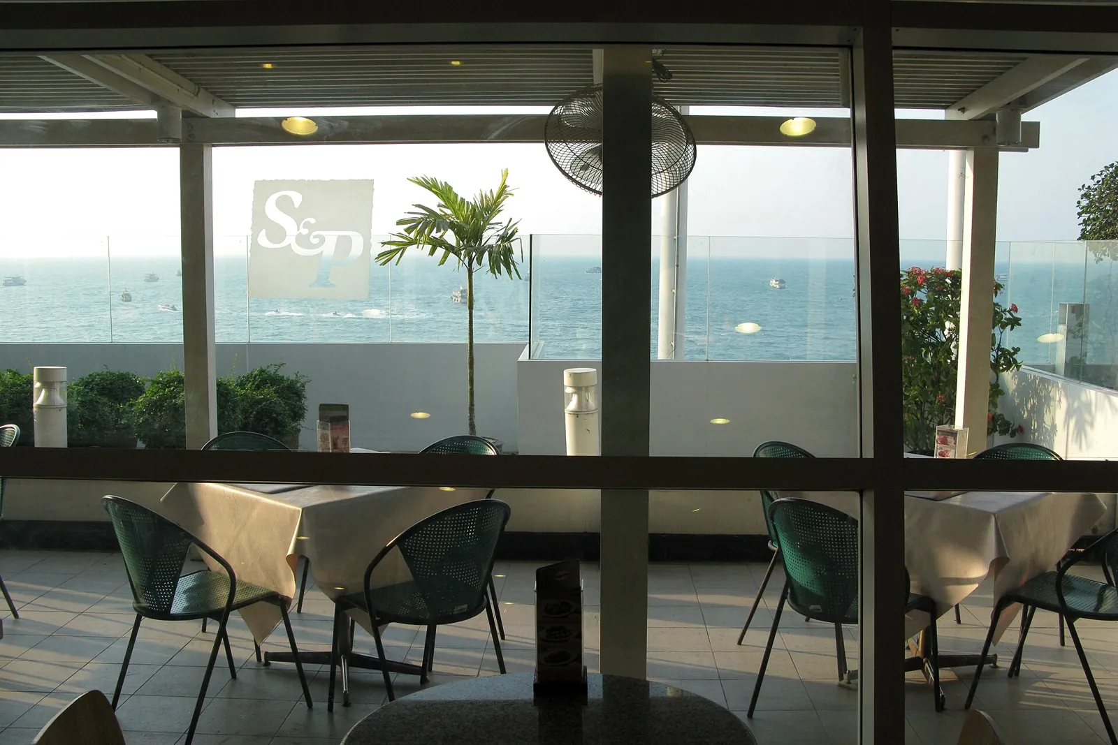A thatched beach cafe on the sand at Pattaya Bay, with the sea in front