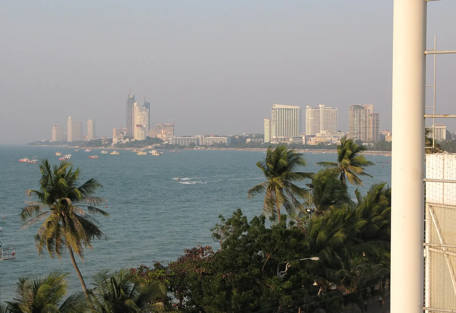The curve of Pattaya Beach with towers behind the sand