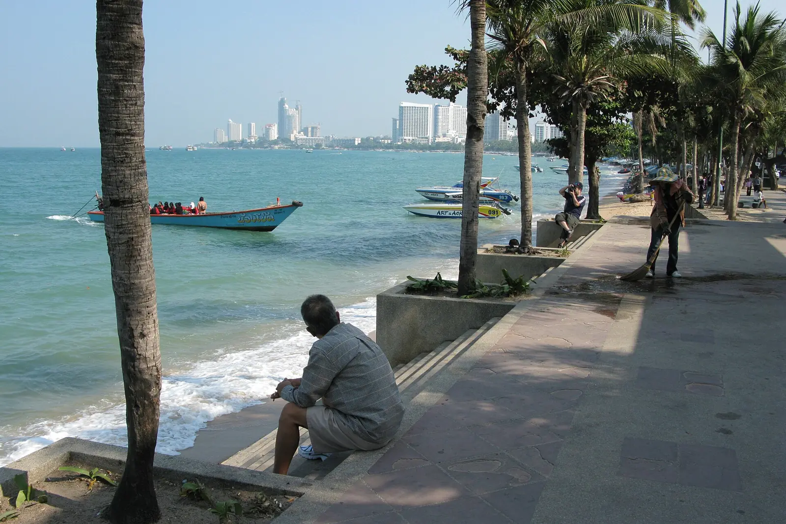 Pattaya Beach Road with the sand, a row of palms and hotel towers behind