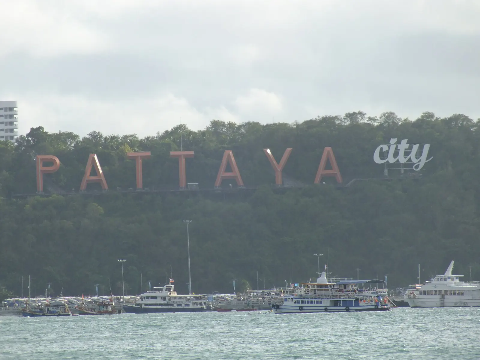 The Pattaya City sign on the beach, with the sand and sea behind it
