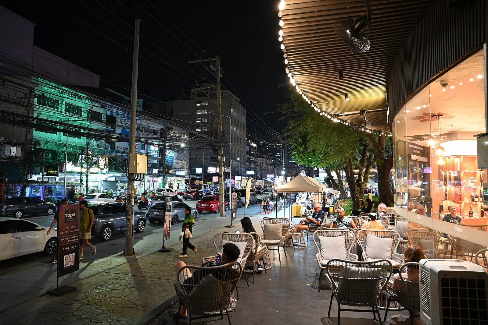 Outdoor cafe seating along a lit Pattaya street at night