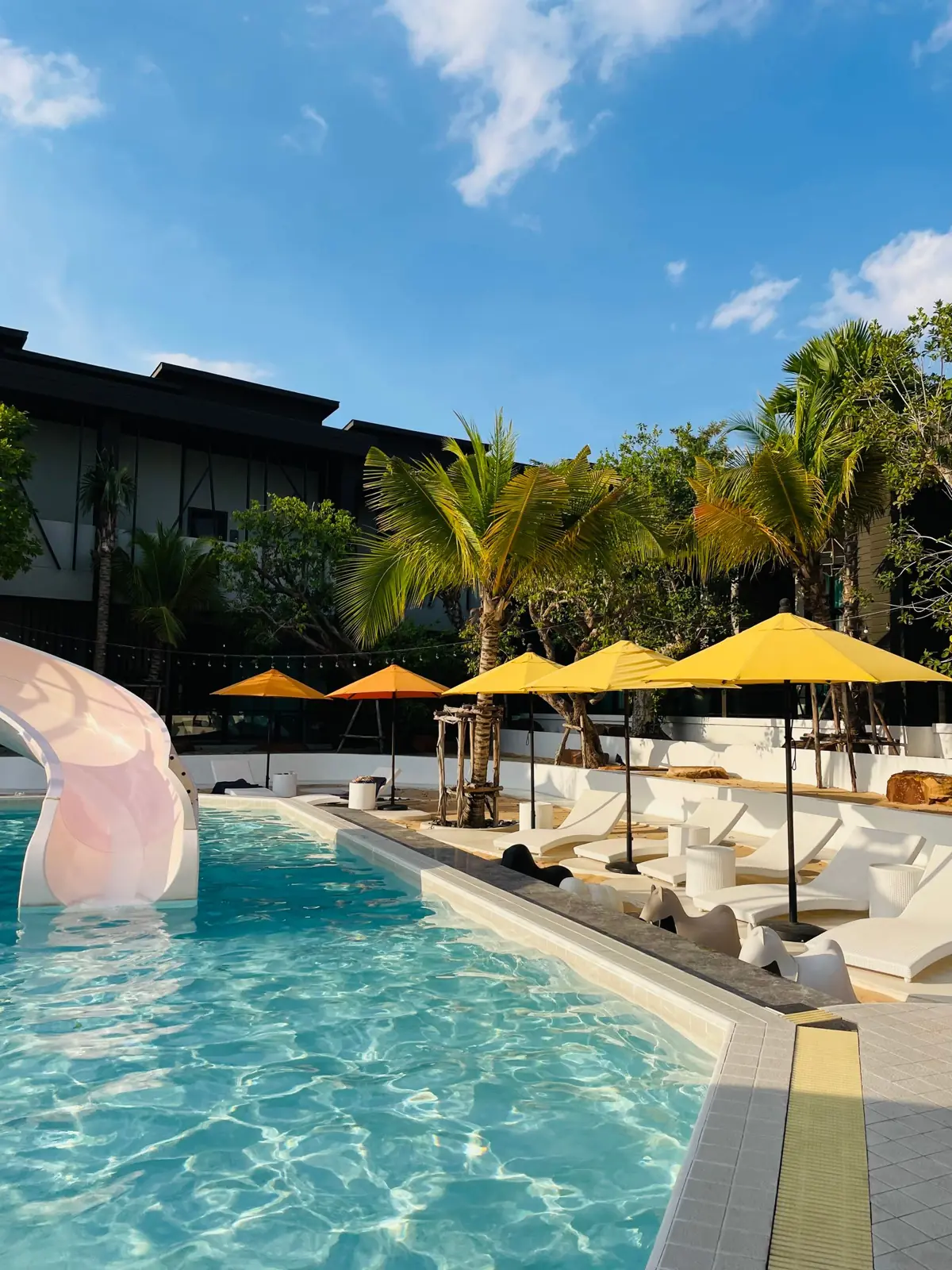 Palm trees and loungers beside a swimming pool at a Pattaya resort
