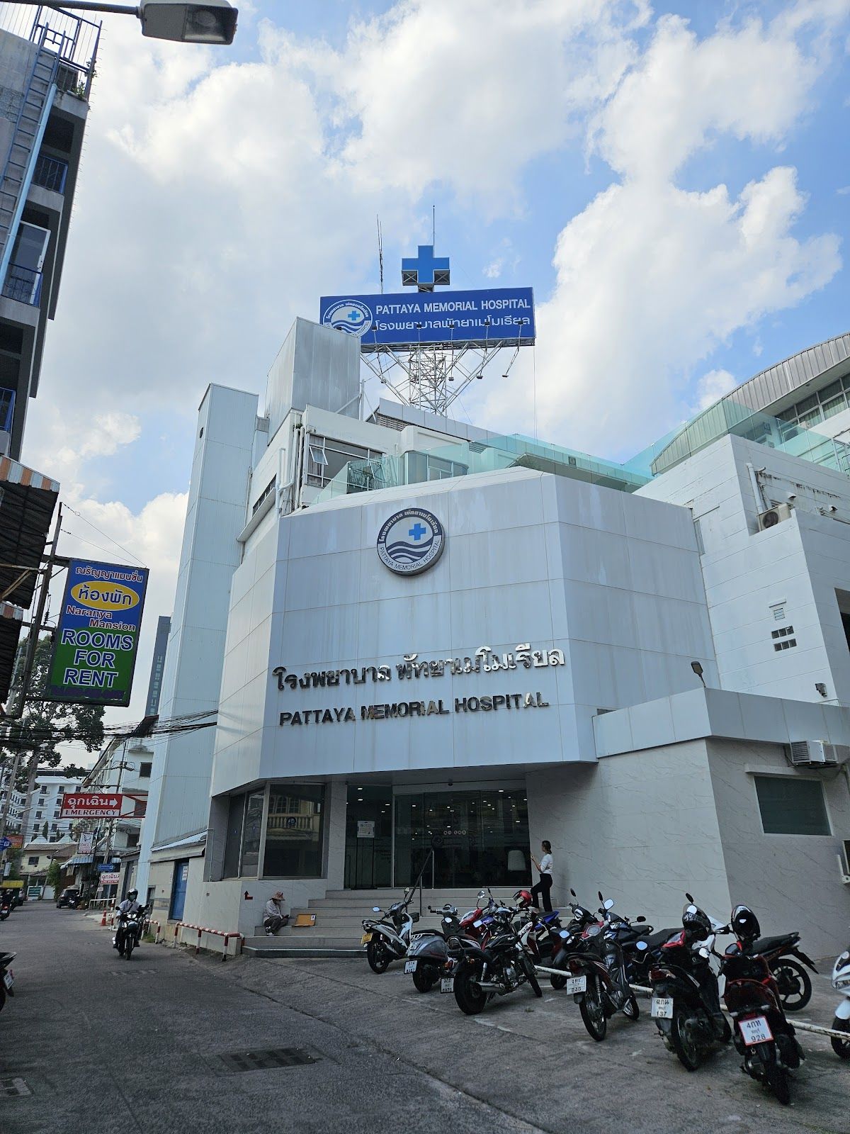 Pattaya Memorial Hospital exterior showing the blue cross logo and entrance on Central Pattaya Road