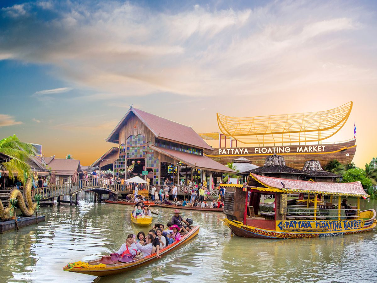 Thai floating market vendor cooking grilled fish and Isan-style food over charcoal at waterside stall