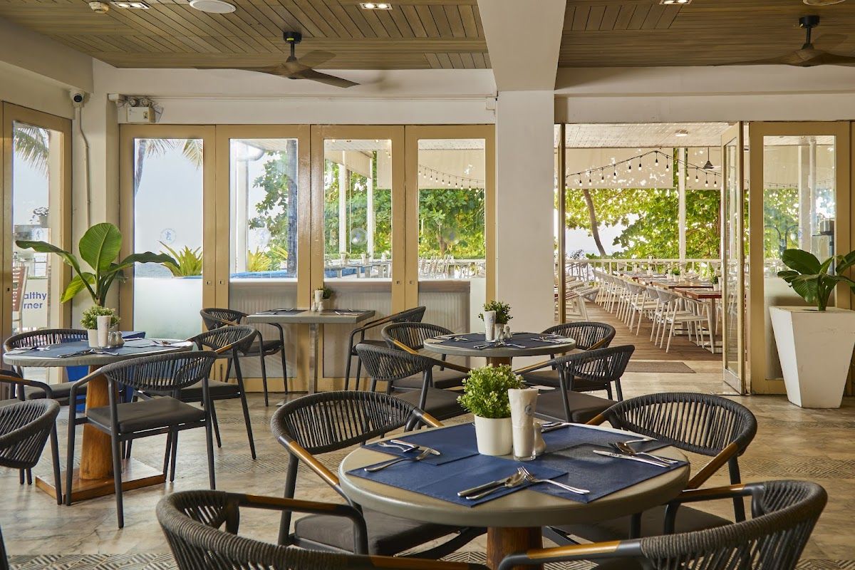 Tropical beach club in Pattaya with turquoise water, sun loungers, and beach umbrellas
