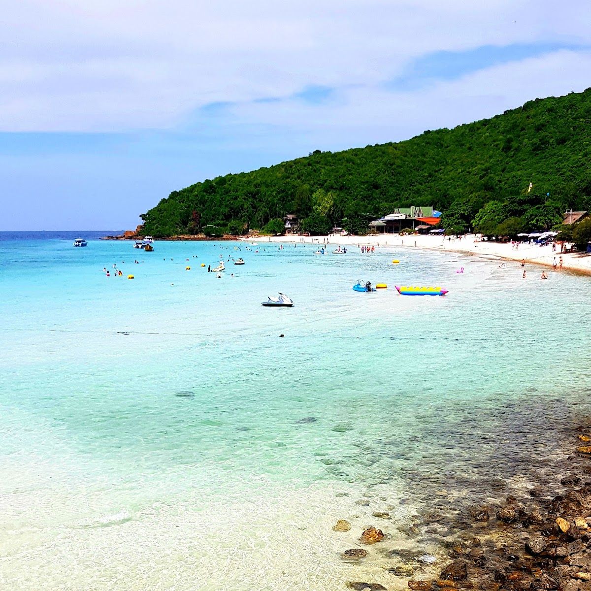 Tawaen Beach Koh Larn Pattaya — golden sand, clear turquoise water and parasailing in the background